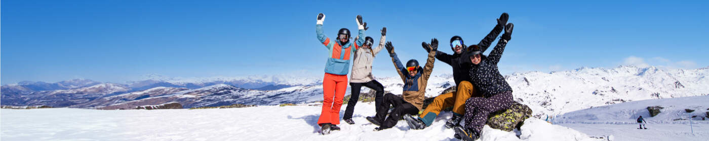 Mennesker på snedækket bjerg afsted på skiferie